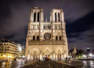 Low angle shot of the facade of notre dame cathedral against a night sky